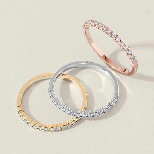 Yellow, white, and rose gold engagement ring bands with polished finishes and different band styles Close-up of multiple gold engagement ring bands in yellow, white, and rose gold, featuring polished finishes and varying band widths