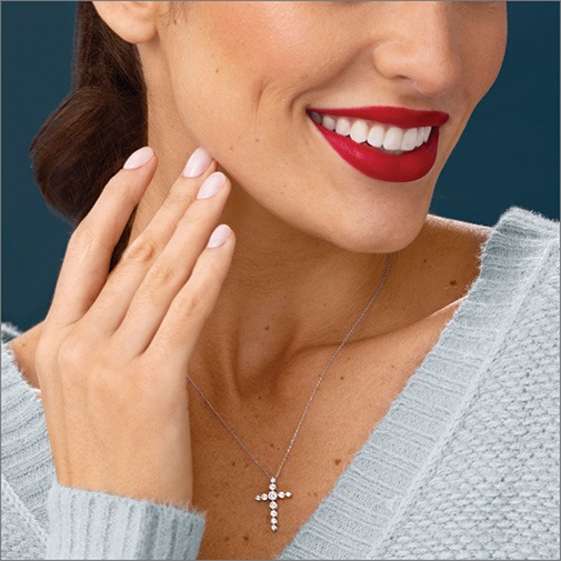 Shop Religious Jewelry for Women Close up of woman wearing a white gold chain with diamond cross pendant