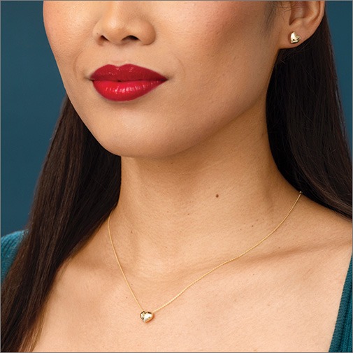 Shop Gold Jewelry for Women Close up of woman wearing yellow gold chain with puffed yellow gold heart pendant