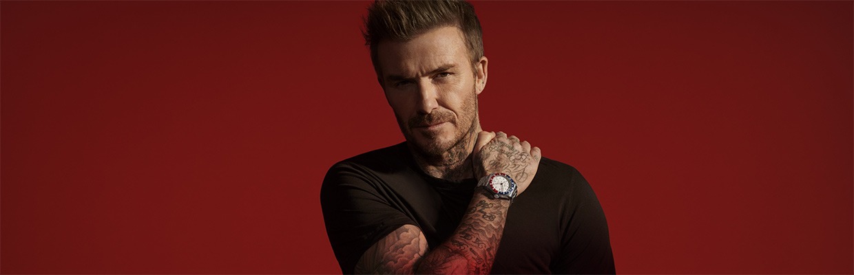 TUDOR Ambassador David Beckham David Beckham wearing a Tudor watch against a red background